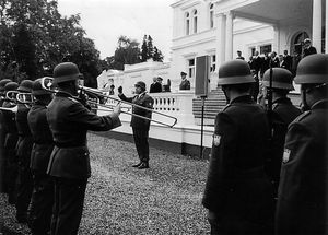 서독 분데스그렌츠슈츠(Bundesgrenzschutz)의 군악대가 독일 연방 대통령 하인리히 뤼브케(Heinrich Lübke, 1959-1969) 앞에서 함머슈미트 빌라(Villa Hammerschmidt)에 있다.