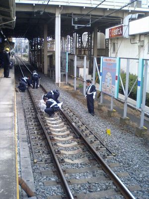 경찰관들이 2006년 2월 사이타마현에서 발생한 자살 현장의 잔해를 치우고 있다