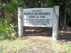 두 개의 둥근 흰색 기둥 사이의 흰색 표지판