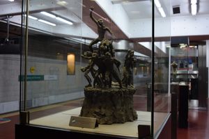 D선의 투쿠만 의회역에 전시된 작품 중 하나. 벽을 따라 조각상이 전시된 유리 케이스에 주목하라.