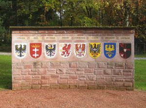 추방자 기념비, 동프로이센, 단치히, 서프로이센, 포메라니아, 브란덴부르크(동부 브란덴부르크), 슐레지엔, 상슐레지엔 및 (원래 오스트리아) 수데텐란트의 문장이 표시되어 있다.