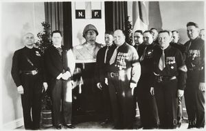 1933년 6월 7일 이탈리아 대표단으로부터 무솔리니의 흉상을 받는 IKL 지도부. 왼쪽부터: 이탈리아 특사 그레이, 이탈리아 대사 타마로, 빌호 안날라, 비흐토리 코솔라, 브루노 살미알라, 유하나 말카매키, 에이노 투오미바아라