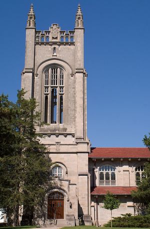 예배당의 석조 타워. 꼭대기에는 장식 요소가 있으며, 나머지 예배당은 오른쪽으로 뻗어 있다.