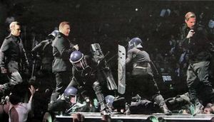 경찰 스타일의 riot gear를 착용한 댄서들과 함께 2011 Brit Awards에서 공연하는 테이크 댓