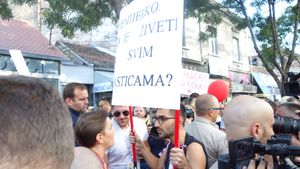 2019년 베오그라드 프라이드 퍼레이드에서 한 참가자가 "총리님, 모든 특권을 누리며 사는 건 어떤가요?"라는 팻말을 들고 있다.