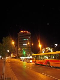 밤에 고층 건물 근처의 버스