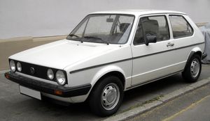 White hatchback car with quad headlights.
