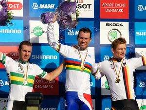 Three men on a podium celebrating with their arms raised