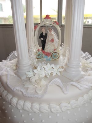 케이크의 층을 분리하는 높은 기둥 안에 장식으로 사용되는 플라스틱 웨딩 토퍼