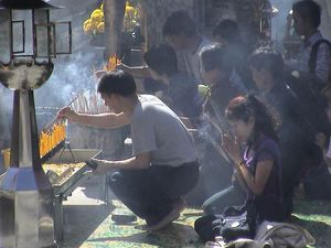 왓 프라깨우에서 향을 피우며 기도하는 불교 신자, 태국