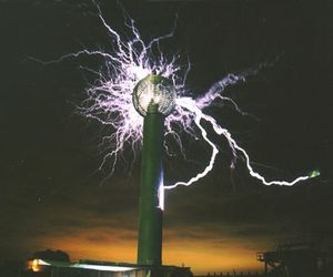 Electrum 조각, 세계 최대의 테슬라 코일. 제작자 에릭 오어가 속이 빈 구형 고전압 전극 안에 앉아 있는 모습이 보인다.