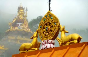 파드마삼바바(Padmasambhava)의 조상 앞에 있는 법륜. 레발사르 호수(Lake Rewalsar), 히마찰프라데시(Himachal Pradesh), 인도