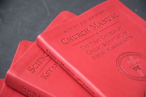 여러 권의 빨간색 하드 커버 책이 쌓여 있음