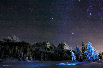 알프스 산 위에 빛나는 별들. 이미지 왼쪽 가장자리에 「?」를 뒤집은 것처럼 별이 늘어선 "사자의 낫(The Sickle)"이 찍혀 있다.