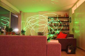 야간 거실의 장노출 사진에서 15 mW 녹색 레이저 포인터의 궤적