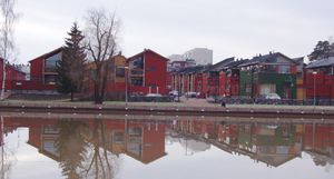 강 건너편 오래된 창고 건물과 어울리도록 설계된 새로운 주택