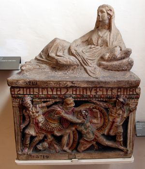 에트루리아 장례용 항아리로 조각된 여성 조각상과 부조 전면 패널에는 두 명의 전사가 싸우는 모습, 다색 테라코타, 기원전 150년경