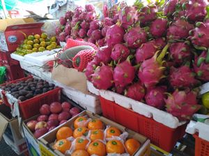 프놈펜 중앙 시장의 캄보디아 과일 노점상, 용과, 감, 사과, 동아, 살락과 포멜로를 판매하고 있다.