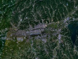 푸순의 위성사진. 좌우(동서)로 흐르는 훈허의 양안에 시가지가 있고 그 남쪽에 2개의 타원형의 큰 노천 광산이 펼쳐져 있다.