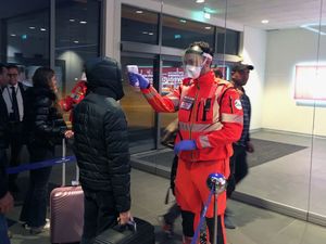 이탈리아 시민보호청의 봉사자가 볼로냐에 위치한 굴리엘모 마코니 공항에서 건강을 체크하고 있는 모습