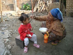 어린 소녀에게 먹이를 주는 와족 여성