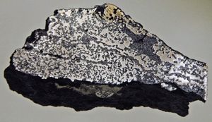 시베리아 트랩 현무암(어두운 색) 샘플로 자생 철을 포함하고 있다.