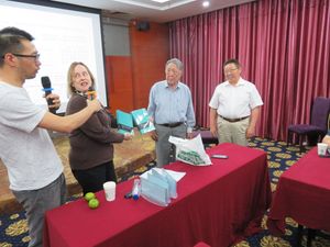 유니코드 컨소시엄 부사장 리사 무어가 2017년 내몽골 후허호트에서 열린 ISO/IEC JTC 1/SC 2 회의에서 초이진자브와 나순우르투에게 유니코드 표준 사본을 전달하고 있다.