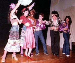 드래그 킹 캐릭터 마초 (오른쪽 끝)가 1977년 로스앤젤레스에서 열린 와일드 사이드 스토리의 "America" 넘버에서 공연하는 모습.