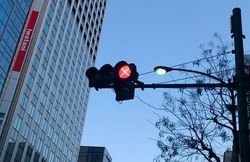 2012년 2월, 도쿄도 시바 우체국 앞 교차로에 시험 설치된 신호등. 빨간 신호에 분홍색으로 ×표시가 되어 있다.