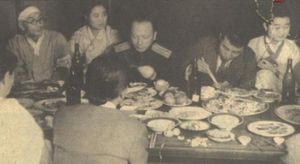1945년 10월 만찬 중 조만식(왼쪽), 메클레르(중앙), 김일성(오른쪽). 배경에 여러 명의 기생(여성 연예인)이 보인다.