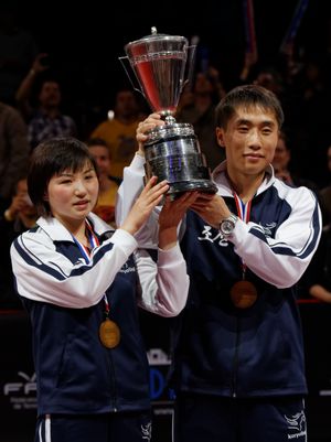 2013년 세계 탁구 선수권 대회에서 혼합 복식 트로피인 헤이두세크 컵을 획득한 북한의 김혁봉과 김종