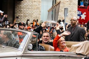 보치가 2012 월드 시리즈 퍼레이드에서 아내 킴과 함께 커미셔너 트로피를 들고 있다.