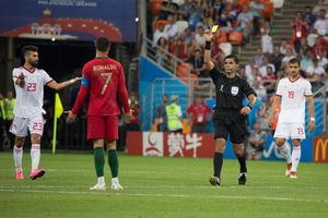 크리스티아누 호날두(포르투갈)가 이란 선수와 충돌 후 엔리케 카세레스 주심이 잠재적인 레드 카드 상황을 검토한 후 옐로 카드를 받는 모습