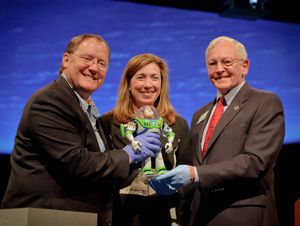 우주 공간에 체류했던 버즈의 피규어는 국립 항공 우주 박물관(NASM)에 기증되었다. 왼쪽부터 감독 래세터, NASA 부차관 가버, NASM 관장 데일리(2012년)