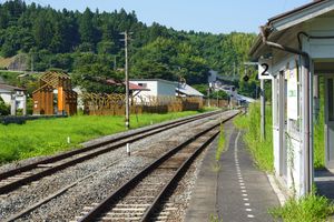 돌과 겐지의 박물관까지의 통로가 역 앞에서 선로를 따라 놓여 있다.