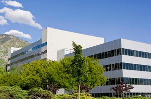 Large, gray, rectangular building with rows of windows lining every other floor