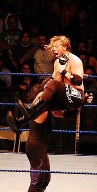 언더테이커가 커트 호킨스에게 원핸드 초크슬램을 시전하고 있다.