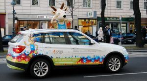 2012년 인스브루크 동계 청소년 올림픽 마스코트가 지켜보는 가운데, 인스브루크 2012 로고가 새겨진 BMW 차량.