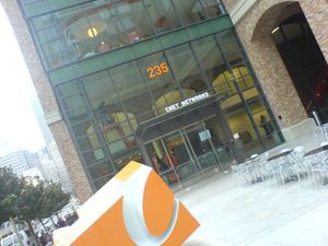 유리 및 벽돌 외관의 건물. 배경에 높은 건물이 보임.