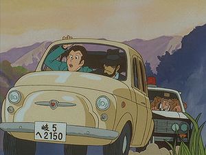 개조된 피아트 500을 탄 루팡과 지겐, 그리고 그 뒤를 쫓는 제니가타 반장