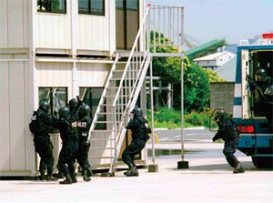 SAT 대원들이 장갑차에서 내려 구조물 진입 준비를 하고 있다.