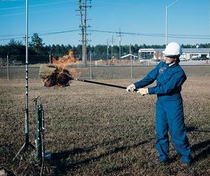 NASA 엔지니어가 수소 화재 위치를 찾기 위해 옥수수 빗자루로 구역을 훑고 있다. 수소는 거의 보이지 않는 불꽃으로 연소된다.
