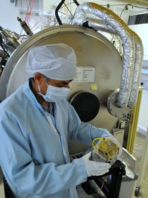 과학자가 큐브위성 섀시를 들고 있는 모습