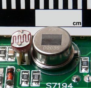 회로 기판에 장착된 수동 적외선 감지기(오른쪽)와 가시광선용 광저항 감지기(왼쪽). 이는 가정용 동작 감지 장치에서 가장 흔하게 사용되는 유형이며, 동작이 감지되고 주변 환경이 충분히 어두울 때만 조명을 켜도록 설계되었다.