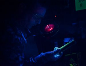 습식 자분 입자를 적용한 후, 미 해군 기술자가 자외선 아래에서 볼트의 균열을 검사하고 있다.