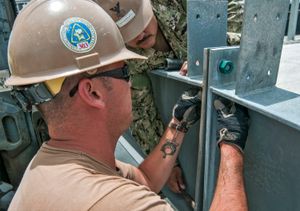 두 부재가 양쪽으로 인장되어 떨어지는 것을 방지하기 위해 볼트를 사용하여 인장 접합하고 있다.