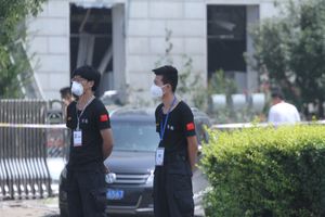 폭발 현장 근처에서 보안 검사원 2명이 방진 마스크를 착용하고 있다.