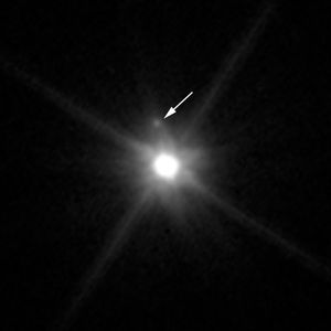 중앙의 밝은 빛이 마케마케이다. 그 왼쪽 위에 보이는 화살표로 표시된 작은 점이 MK2이다.