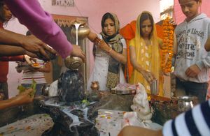 시바의 신자들이 요니 링감에 과일과 꽃을 바치는 모습. 조각된 요니의 입술에 핀 Datura metel의 꽃 봉오리를 확인하십시오 (작은 놋쇠 냄비 아래 및 왼쪽에 있음).