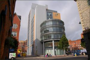 다른 구조물들을 중심으로 유리로 된 큰 정면을 가진 다층 건물